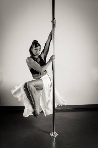 Female pole dancer of color Women of color pole dancing. Pole dance is both exotic and athletic. Strength and grace are required to create beautiful lines and shapes as a pole dancer and aerialist. black pole dancers stock pictures, royalty-free photos & images