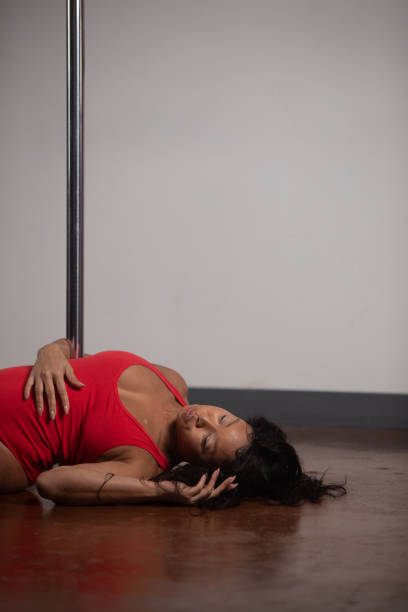 Female pole dancer of color Women of color pole dancing. Pole dance is both exotic and athletic. Strength and grace are required to create beautiful lines and shapes as a pole dancer and aerialist. black pole dancers stock pictures, royalty-free photos & images