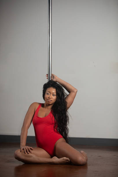Female pole dancer of color Women of color pole dancing. Pole dance is both exotic and athletic. Strength and grace are required to create beautiful lines and shapes as a pole dancer and aerialist. black pole dancers stock pictures, royalty-free photos & images