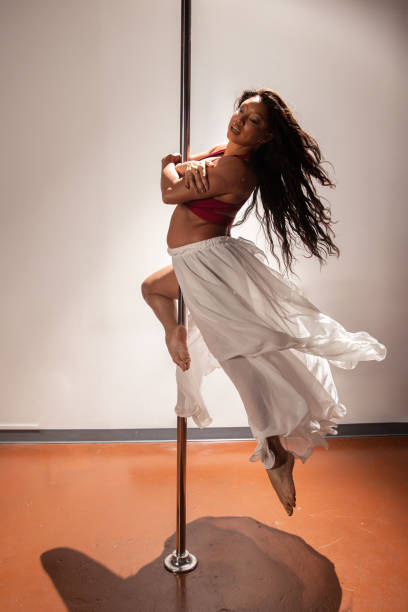Female pole dancer of color Women of color pole dancing. Pole dance is both exotic and athletic. Strength and grace are required to create beautiful lines and shapes as a pole dancer and aerialist. black pole dancers stock pictures, royalty-free photos & images