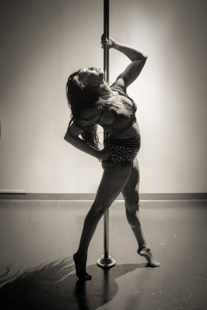 Female pole dancer of color Women of color pole dancing. Pole dance is both exotic and athletic. Strength and grace are required to create beautiful lines and shapes as a pole dancer and aerialist. black pole dancers stock pictures, royalty-free photos & images