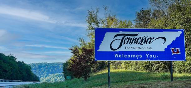 State Line Sign to Tennessee, USA Tennessee, USA -- October 1, 2021: "Tennessee Welcomes You" sign on the US state line from Georgia to Tennessee. Message also reads, "The Volunteer State" (referring to the US Civil War draft status.) tennessee road sign stock pictures, royalty-free photos & images
