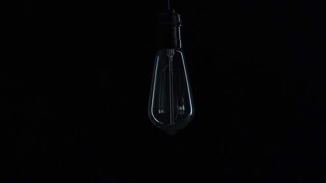 Incandescent light bulb in dark background