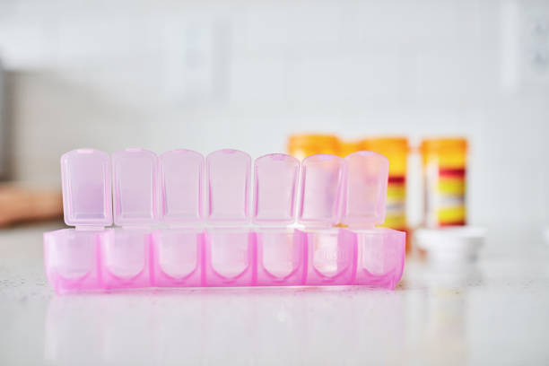 istock Open pink pill container on kitchen counter ready to be filled with prescription medicine 1358349777