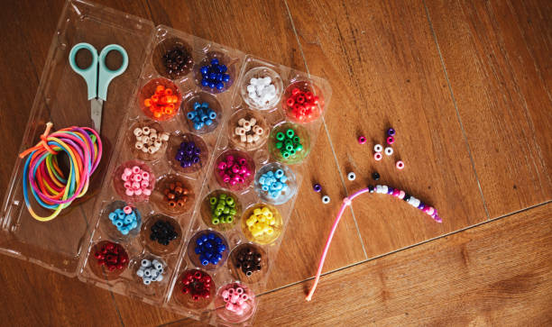 istock Plastic egg box being used to store plastic beads for children's crafts. Recycling and making friendship bracelets 1358349949