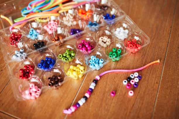 istock Plastic egg box being used to store plastic beads for children's crafts. Recycling and making friendship bracelets 1358349957