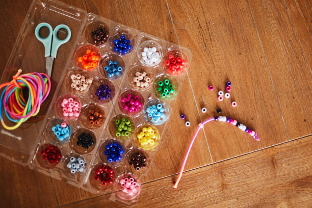 istock Plastic egg box being used to store plastic beads for children's crafts. Recycling and making friendship bracelets 1358349994