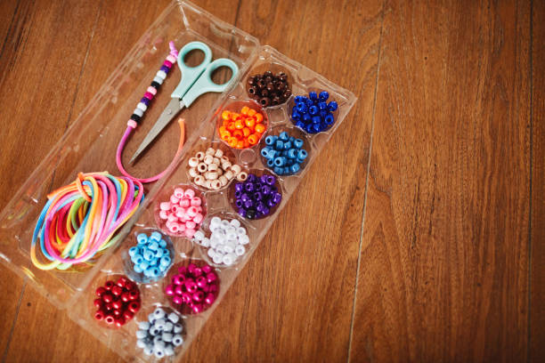 istock Plastic egg box being used to store plastic beads for children's crafts. Recycling and making friendship bracelets 1358350024