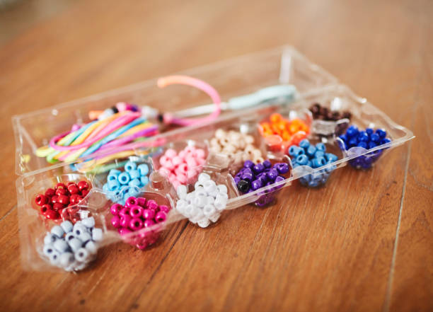 istock Plastic egg box being used to store plastic beads for children's crafts. Recycling and making friendship bracelets 1358350039