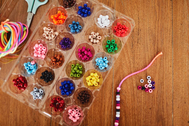 istock Plastic egg box being used to store plastic beads for children's crafts. Recycling and making friendship bracelets 1358350040