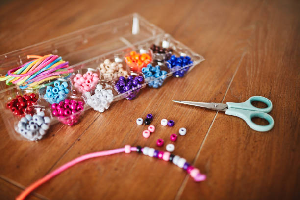 istock Plastic egg box being used to store plastic beads for children's crafts. Recycling and making friendship bracelets 1358350062