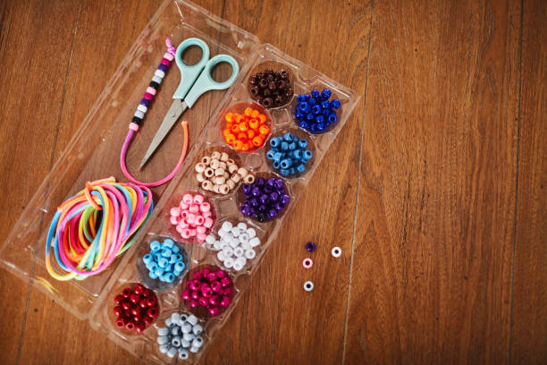 istock Plastic egg box being used to store plastic beads for children's crafts. Recycling and making friendship bracelets 1358350068
