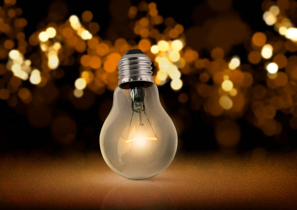 istock Naked bulb glowing in the dark 1358351860