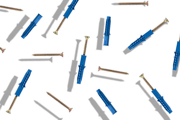 Metal screws and plastic dowels on a white background with shadows