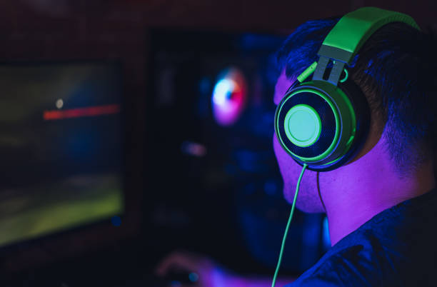 istock Guy playing video games in computer club under neon lighting 1358354657