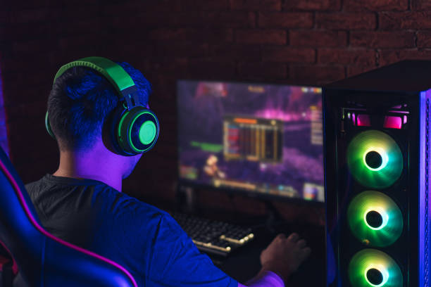 istock Guy in green headphones playing video games under neon light 1358354662