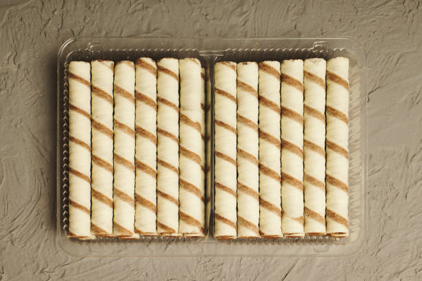 istock Sweet cookie straws in a plastic container on a gray table. 1358355478