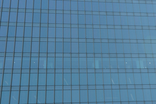 Austin, Texas- Low angle view of a building with reflective glass exterior. Glass building exterior against the blue sky background.