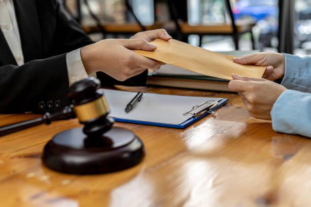 istock Attorneys are accepting documents from clients who come in to testify in case of embezzlement from business partners who venture into business. The concept of hiring a lawyer for legal proceedings. 1358359448
