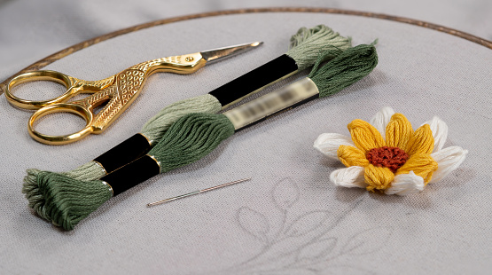 Embroidery with hand stitching flower scissors needle and floss threads
