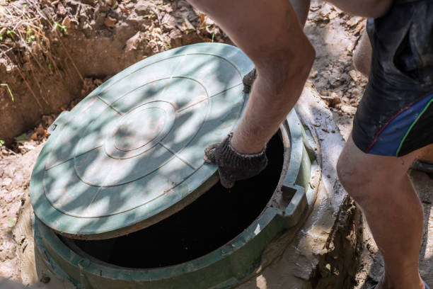 The man opens the sewer hatch. Installation and maintenance of septic tanks The man opens the sewer hatch. Installation and maintenance of septic tanks. poisonous stock pictures, royalty-free photos & images