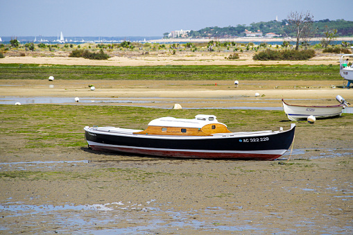 White and blue pinasse at low tide, a wooden boat typical of the Arcachon bay, France