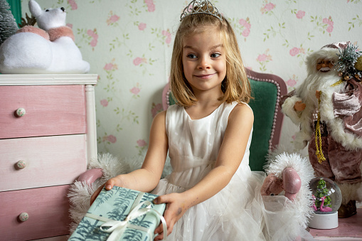 Cute little girl in orange dress posing over white background. Little princess girl portrait