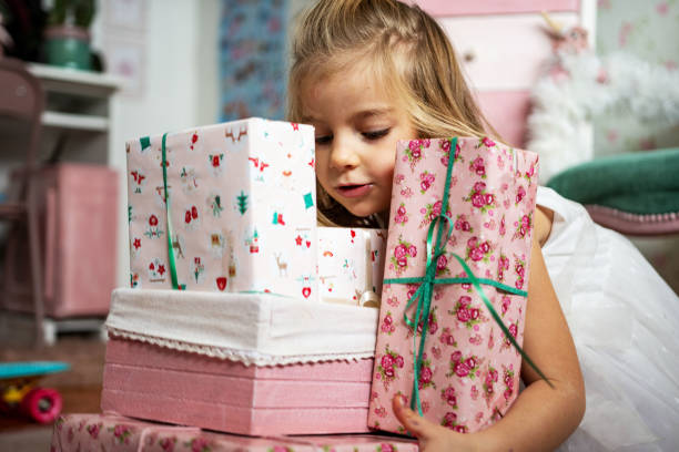 istock Cute girl holding Christmas gift boxes 1358374980