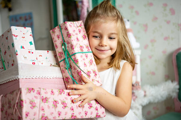 istock Cute girl holding Christmas gift boxes 1358374992