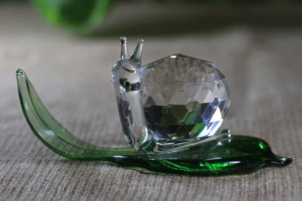 istock Glass souvenir. Snail on a green leaf. 1358377308