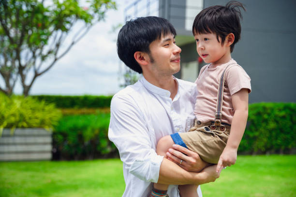 istock Asian father happily hugging his son. 1358384886