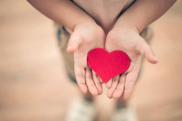 istock little boy hold heart. 1358385814