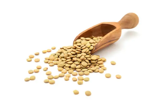 Healthy food, Lentils in wooden scoop on white background