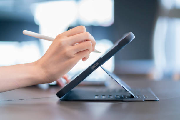 istock Close up of female hand using digital pen writing on digital tablet screen 1358390468