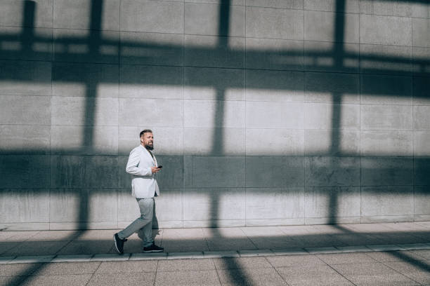 istock Mature businessman using mobile phone in the city 1358396947