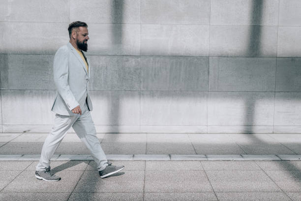istock Mature businessman walking outside office building 1358397034