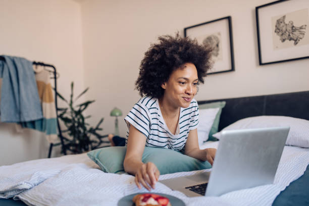istock Young African American woman working from the bed 1358399403