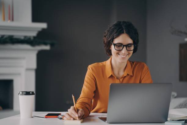 istock Pleasant happy young hispanic woman freelancer working on laptop computer at home 1358401621