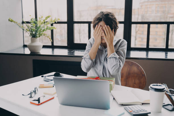 istock Curious woman office employee covering eyes with hands while getting x-mas present at work 1358401643
