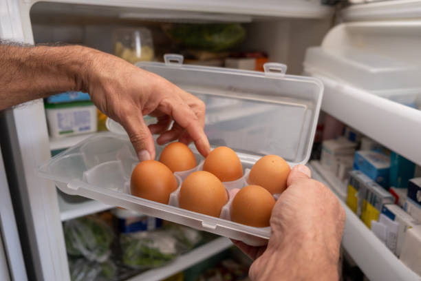 Person who takes eggs from egg storage box made of 5 pp Person receiving eggs in an egg box made of 5 pp material from the refrigerator at home Eggs stock pictures, royalty-free photos & images