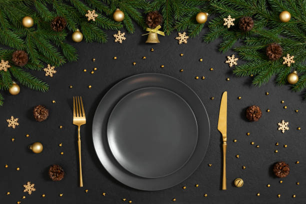 istock Golden Christmas table setting with festive decorations on a black background. Happy new year. Space for text. Winter concept. Top view, flat lay. 1358402437