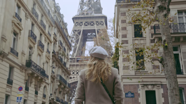 SLO MO French woman walks down the street toward the Eiffel Tower