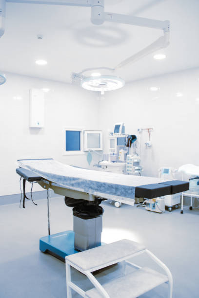 istock Empty operating room in a hospital. Surgical equipment with operating table. Medical device for emergency patient in blue tone style. Blank Emergency Surgery Room. Clinic interior for background 1358405856