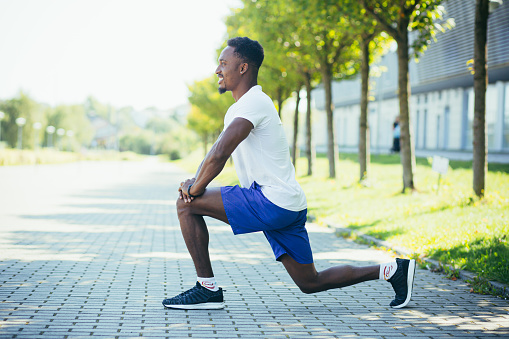 Athletic African American man doing morning workouts, stretching and fitness