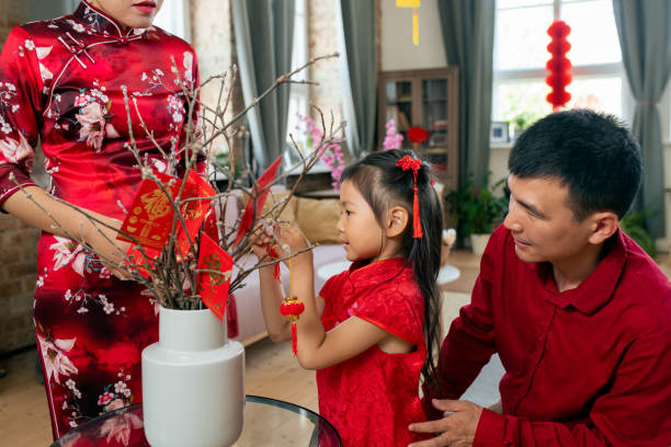 istock Cute little girl decorating branches with handmade postcards 1358407940
