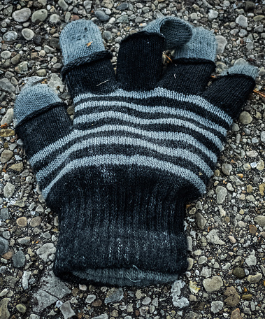 Black and gray lost glove in the street.