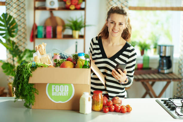 istock happy young female with food box in kitchen 1358411907