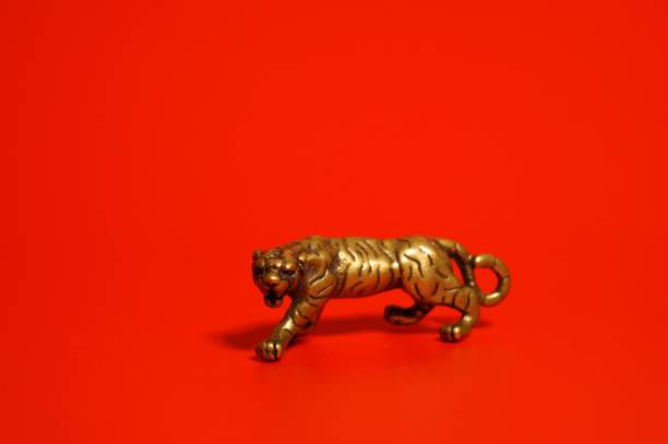 istock Metal tiger figurine on a red background. 1358413179
