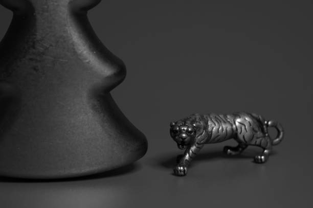 istock A metal tiger figurine and a Christmas tree on a red background. 1358413209