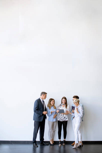 istock Business people standing by the wall in the office 1358416757